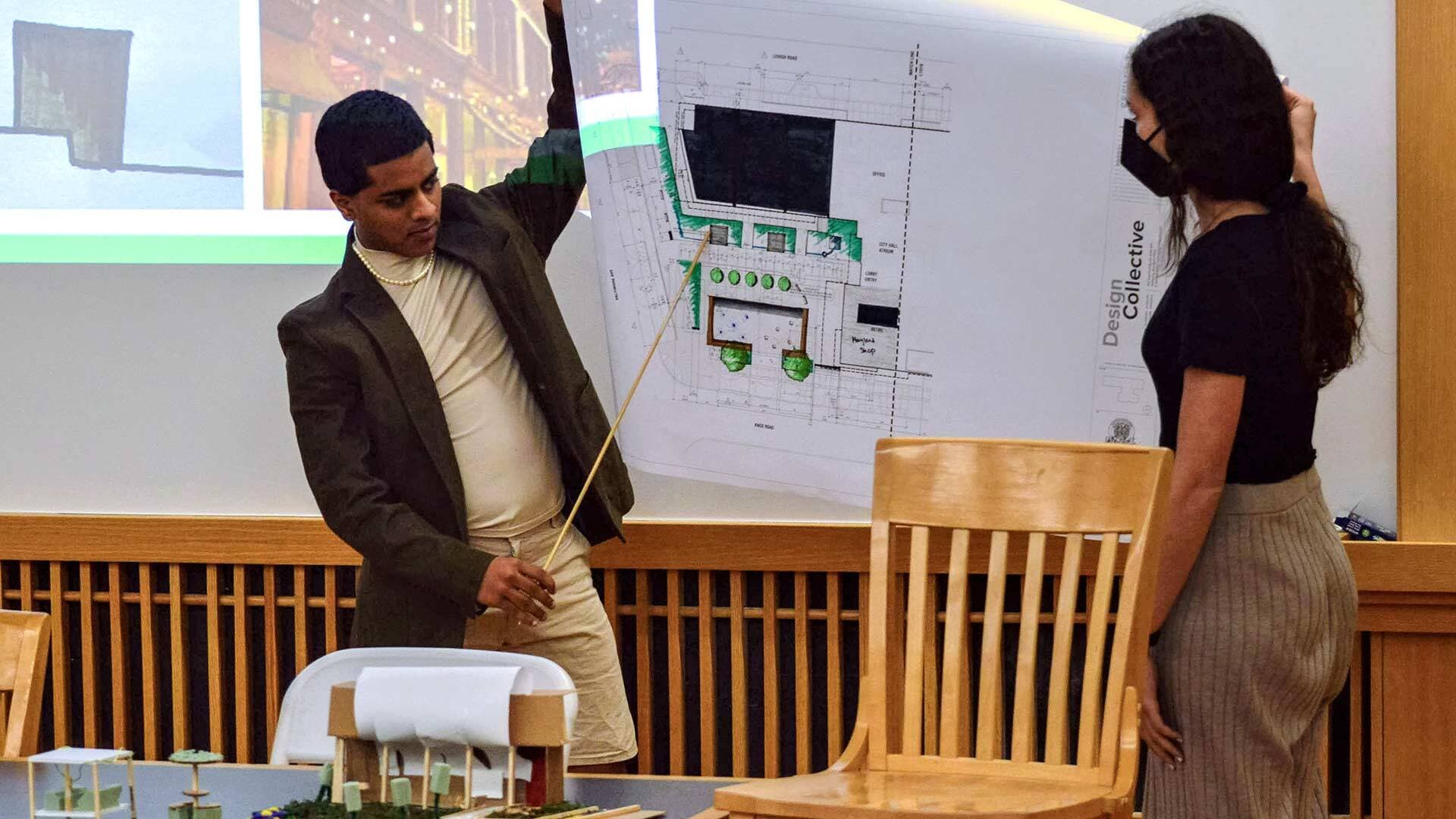 Students explain blueprint of their design at PlaceHack competition