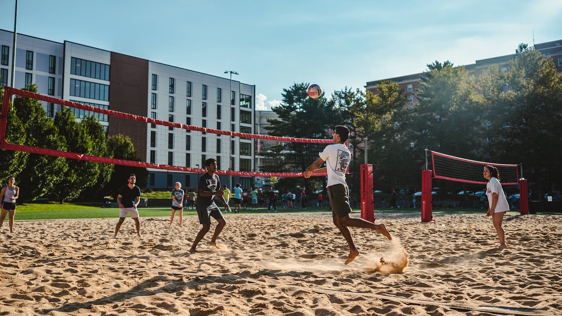 students play beach volleyball