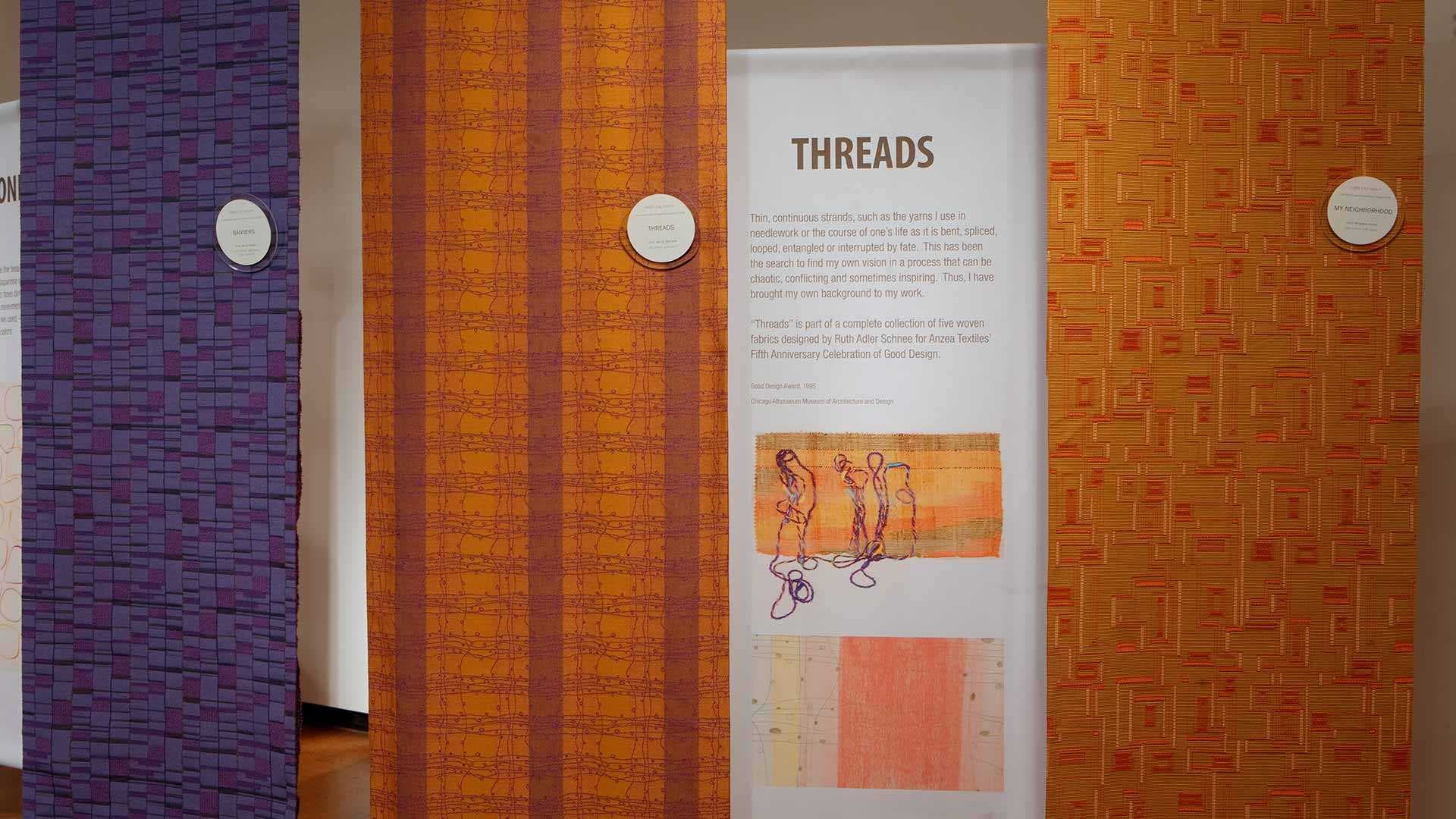 sign from “Ruth Adler Schnee: A Passion for Color & Design” exhibition showing orange threads