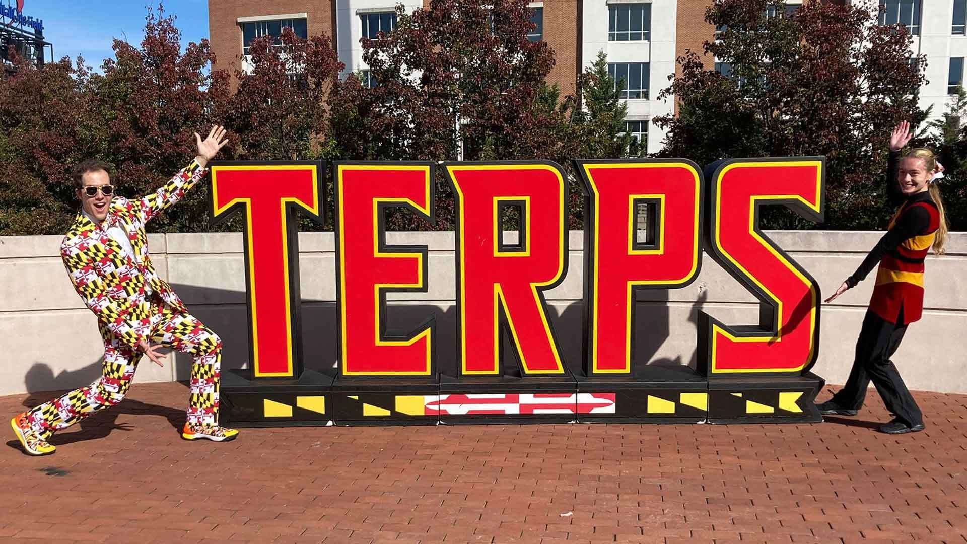 Flag Suit Guy poses next to TERPS sign