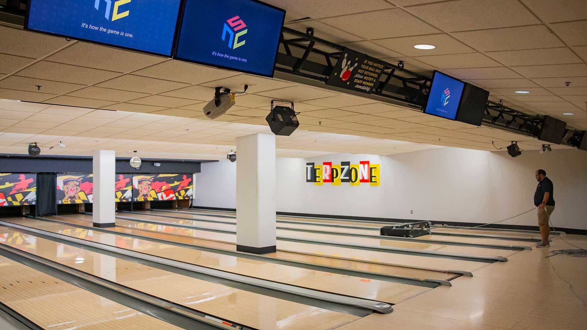 Staff member oils lanes at bowling alley