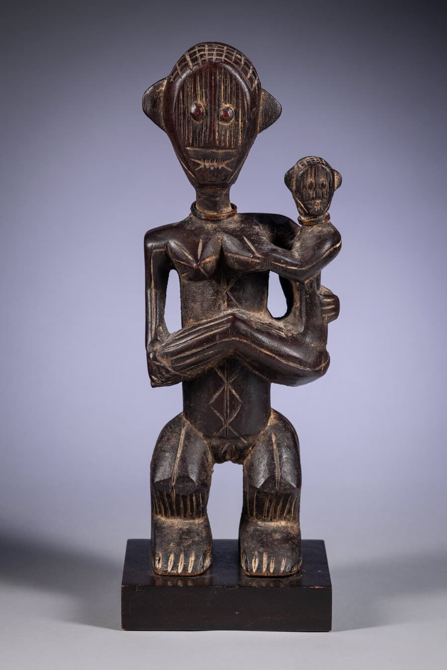 Wooden figurine of a mother holding a child