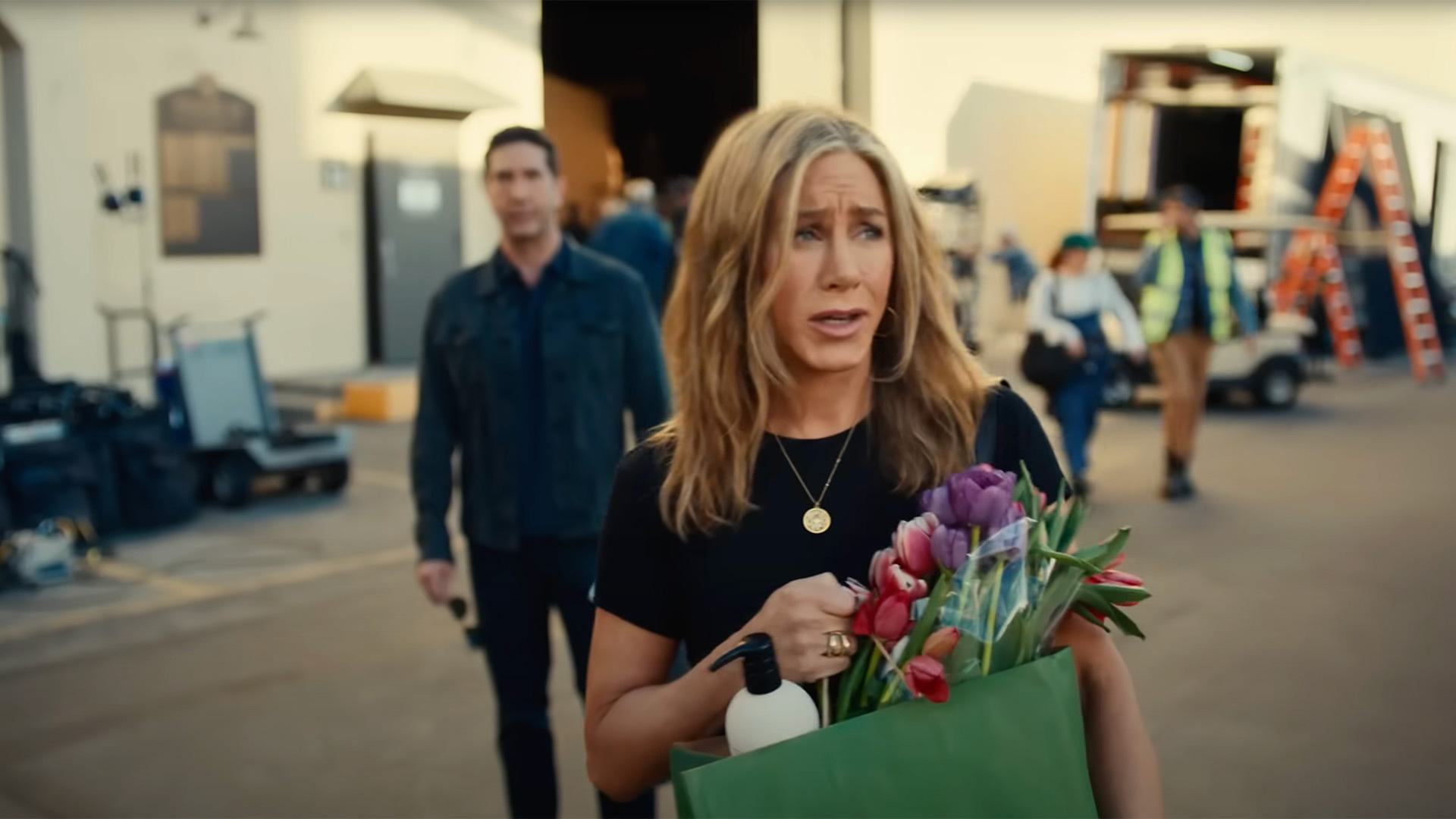Jennifer Aniston holding a bag of flowers