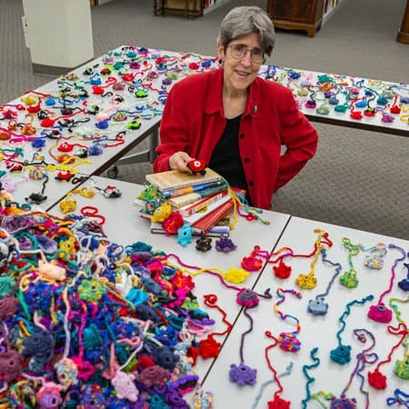 Anne Turkos poses with crocheted turtle bookmarks