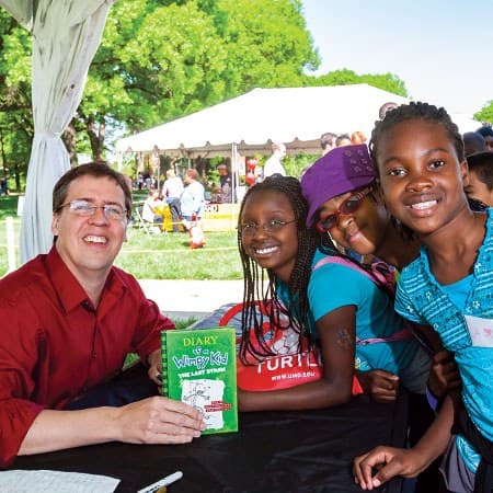 Jeff Kinney poses with "Diary of a Wimpy Kid" book and fans