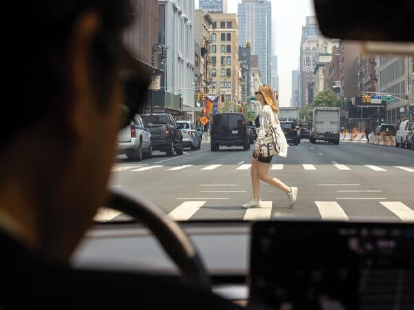 view from windshield of taxi of woman crossing NYC street