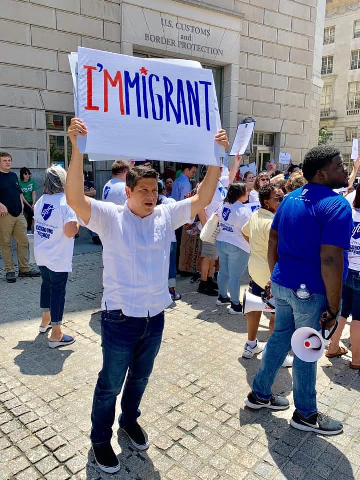 protestor with sign that reads, "I'm-migrant"